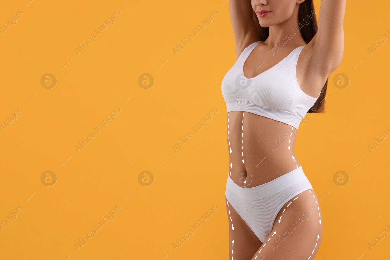 Image of Woman showing her beautiful figure on orange background, closeup. Space for text. Cosmetic treatment lines on her body