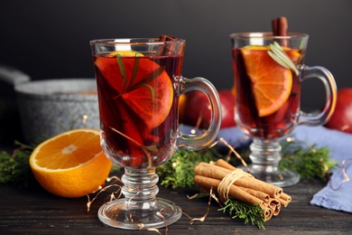 Photo of Tasty mulled wine with spices on wooden table