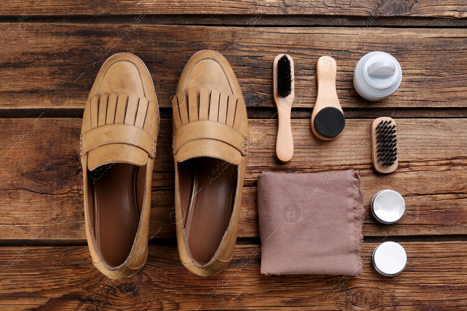 Photo of Flat lay composition with shoe care accessories and footwear on wooden background