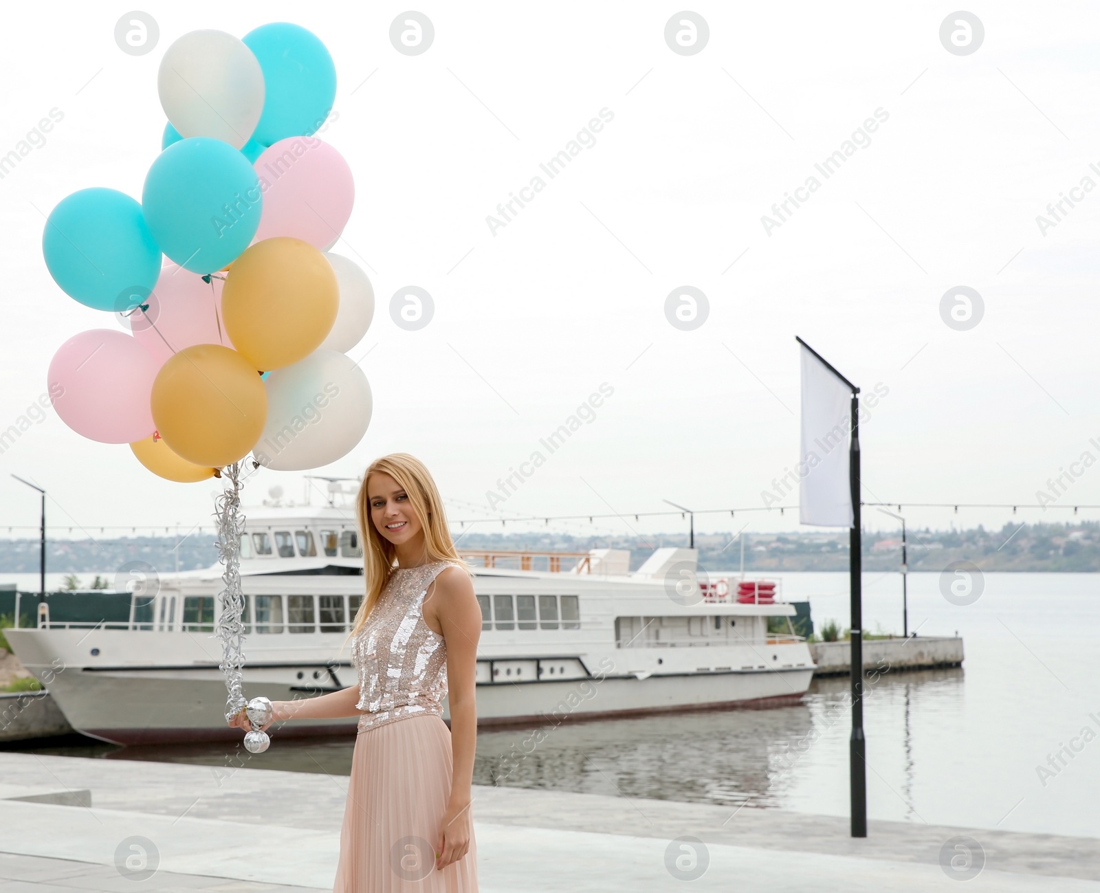 Photo of Beautiful young woman with bunch of balloons outdoors. Space for text