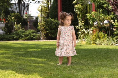 Photo of Cute little girl walking on green grass in park