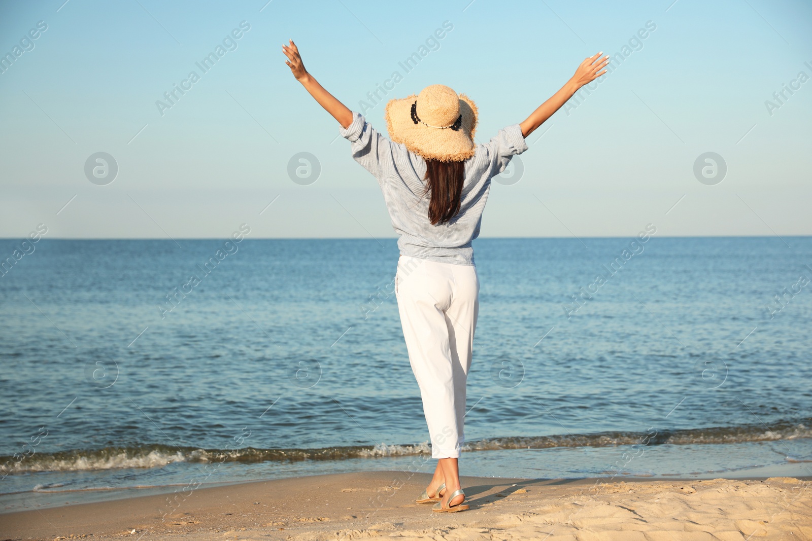 Photo of Beautiful young woman in straw hat on beach