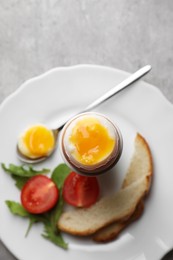 Breakfast with soft boiled egg on grey table, top view. Space for text