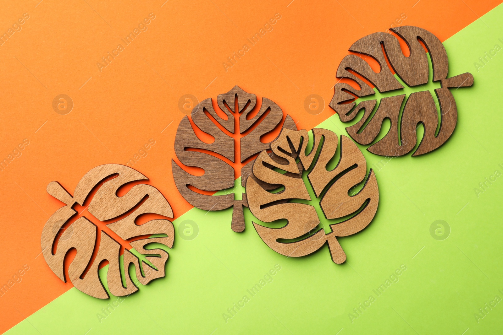 Photo of Leaf shaped wooden cup coasters on color background, flat lay