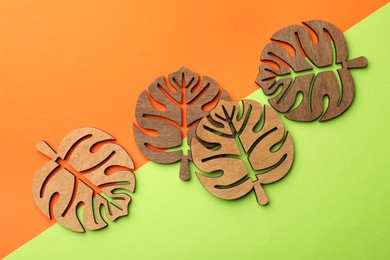 Leaf shaped wooden cup coasters on color background, flat lay