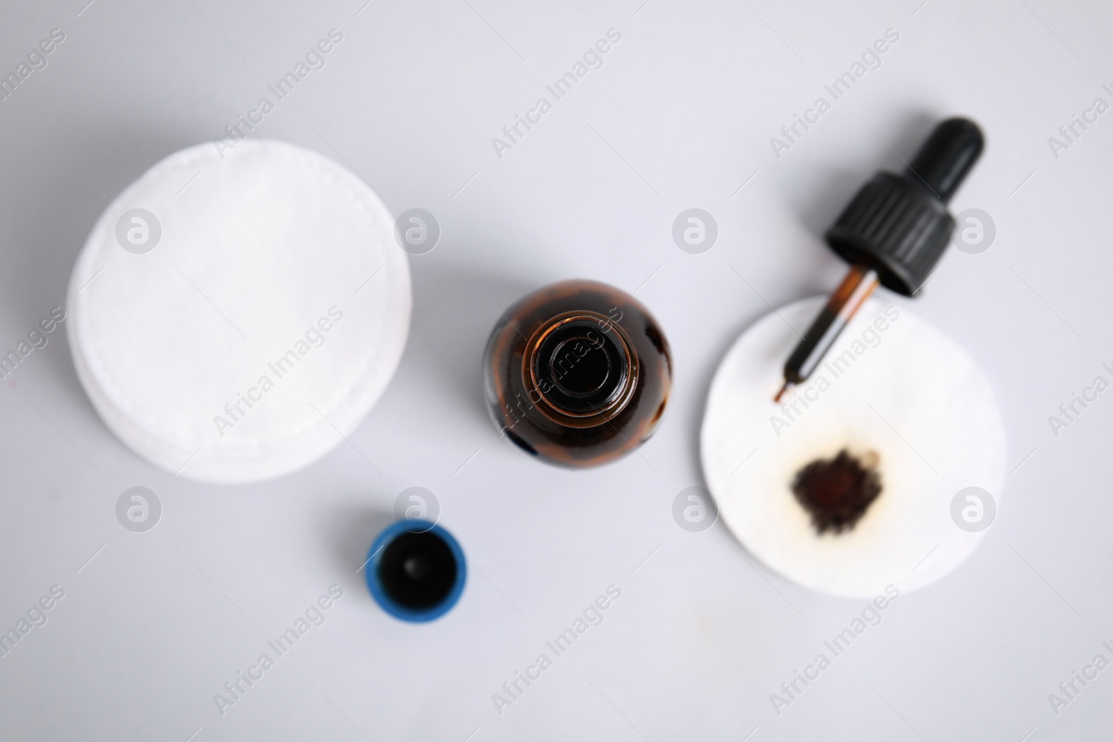 Photo of Bottle of medical iodine, dropper and cotton pads on grey background, flat lay