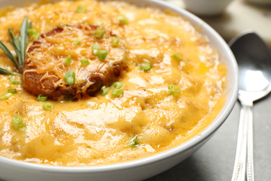 Tasty homemade French onion soup in bowl, closeup