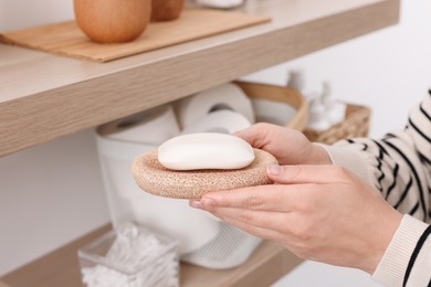 Photo of Bath accessories. Woman with soap indoors, closeup