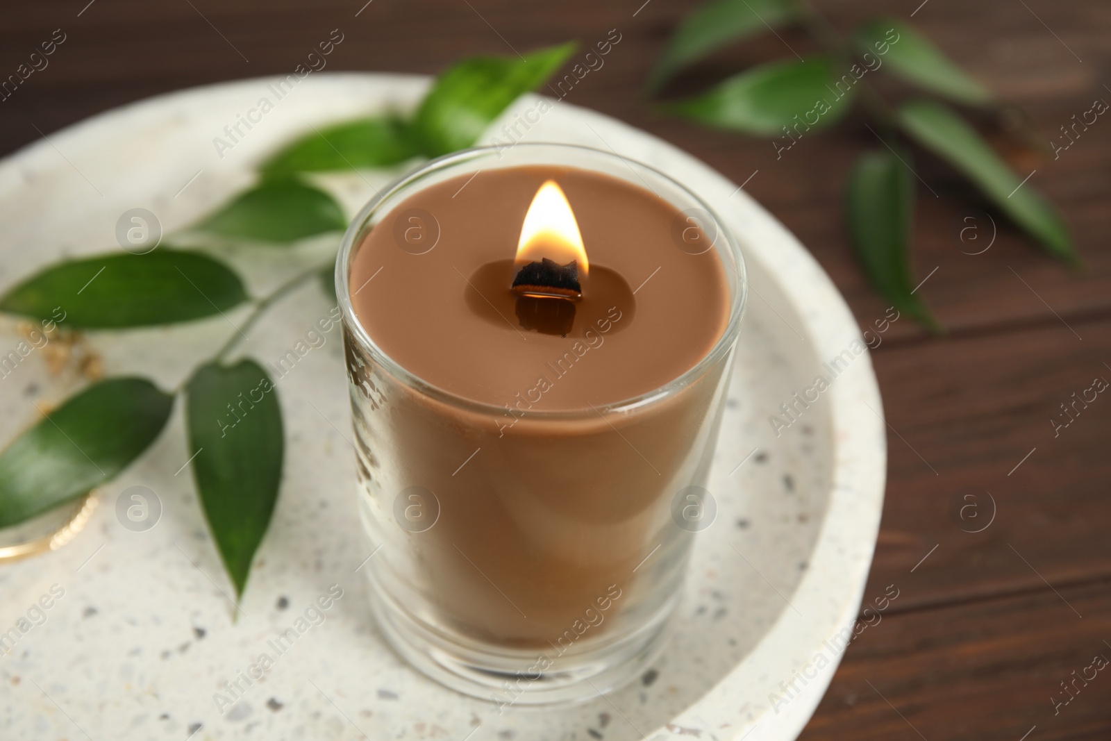 Photo of Burning candle with wooden wick on tray