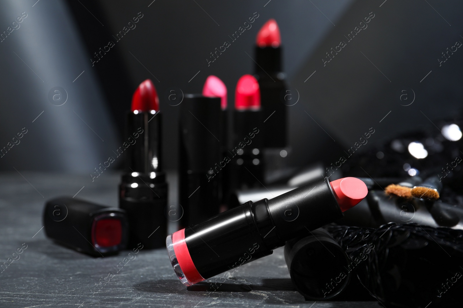 Photo of Different beautiful lipsticks on grey marble table, closeup