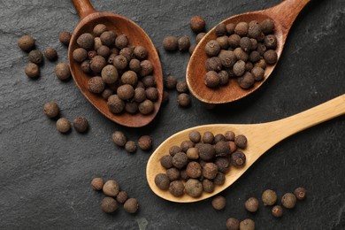 Photo of Dry allspice berries (Jamaica pepper) on black table, top view