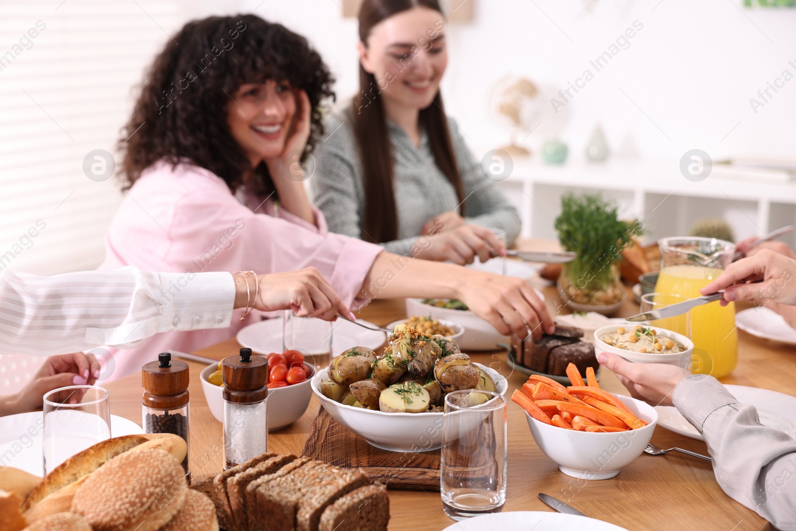 Photo of Friends eating vegetarian food at table indoors