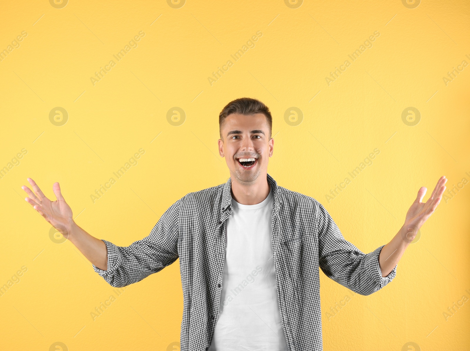 Photo of Handsome emotional young man on color background