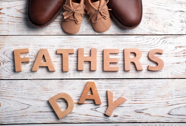 Photo of Flat lay composition with shoes and words FATHER'S DAY on wooden background