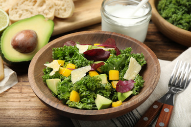 Photo of Delicious kale salad served on wooden table