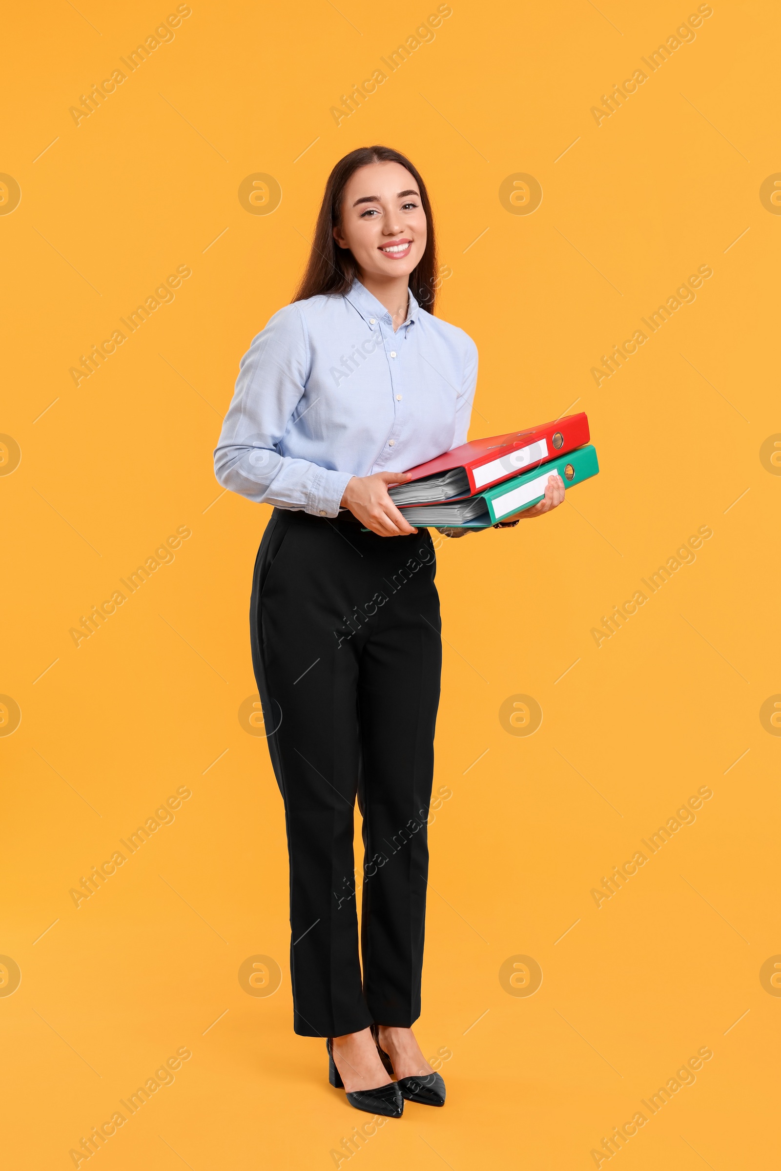 Photo of Happy woman with folder on orange background