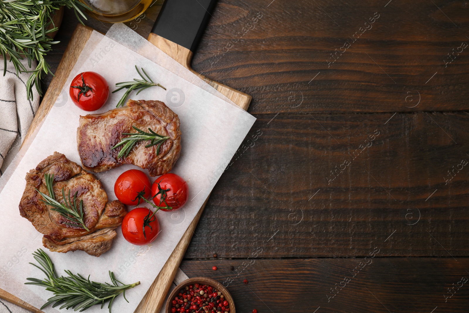 Photo of Delicious fried meat with rosemary, tomatoes and spices on wooden table, flat lay. Space for text