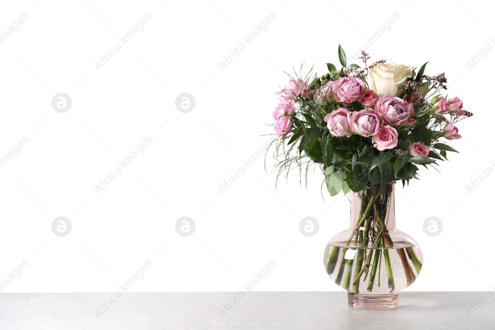 Photo of Beautiful bouquet with roses on grey table against white background
