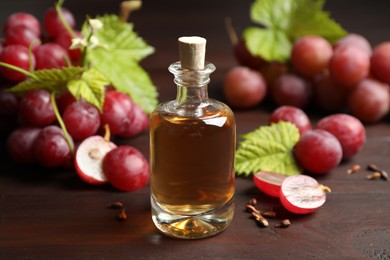Photo of Bottle of natural grape seed oil on wooden table. Organic cosmetic