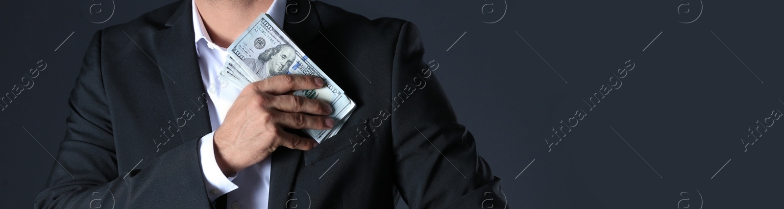 Image of Man putting bribe into pocket on black background, closeup with space for text. Banner design