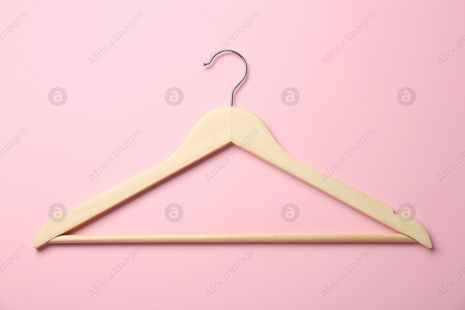 Photo of Wooden hanger on pink background, top view