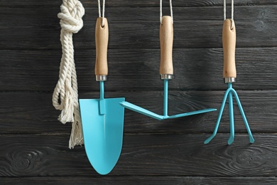 Photo of Set of professional gardening tools hanging on wooden wall