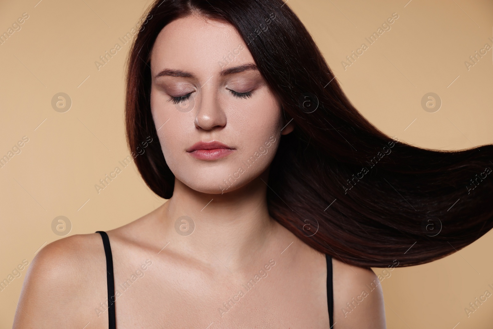 Photo of Portrait of beautiful young woman with healthy strong hair on beige background