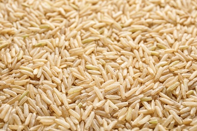 Photo of Pile of raw unpolished rice as background, closeup