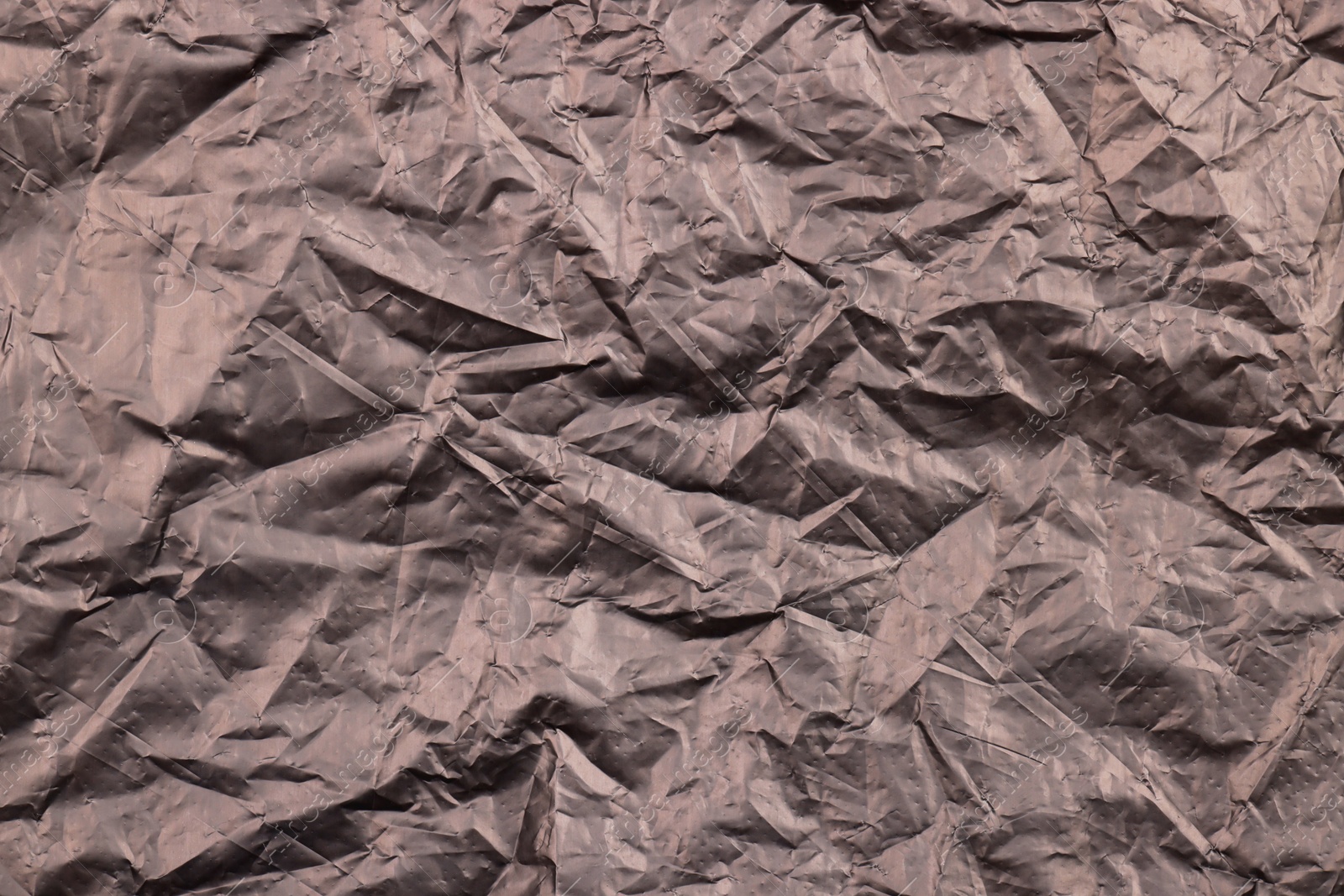 Photo of Crumpled black plastic bag as background, top view
