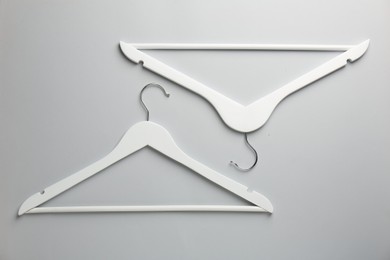 Photo of White hangers on light gray background, flat lay