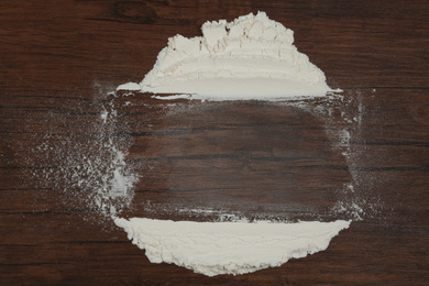 Flour on wooden background, top view. Space for text