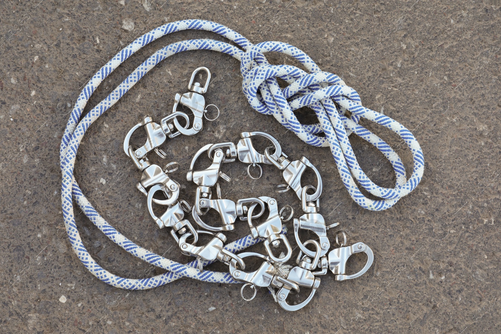 Photo of Climbing rope with carabiners on asphalt, top view