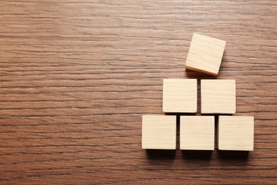 Photo of Blank cubes on wooden table, flat lay with space for text. Idea concept