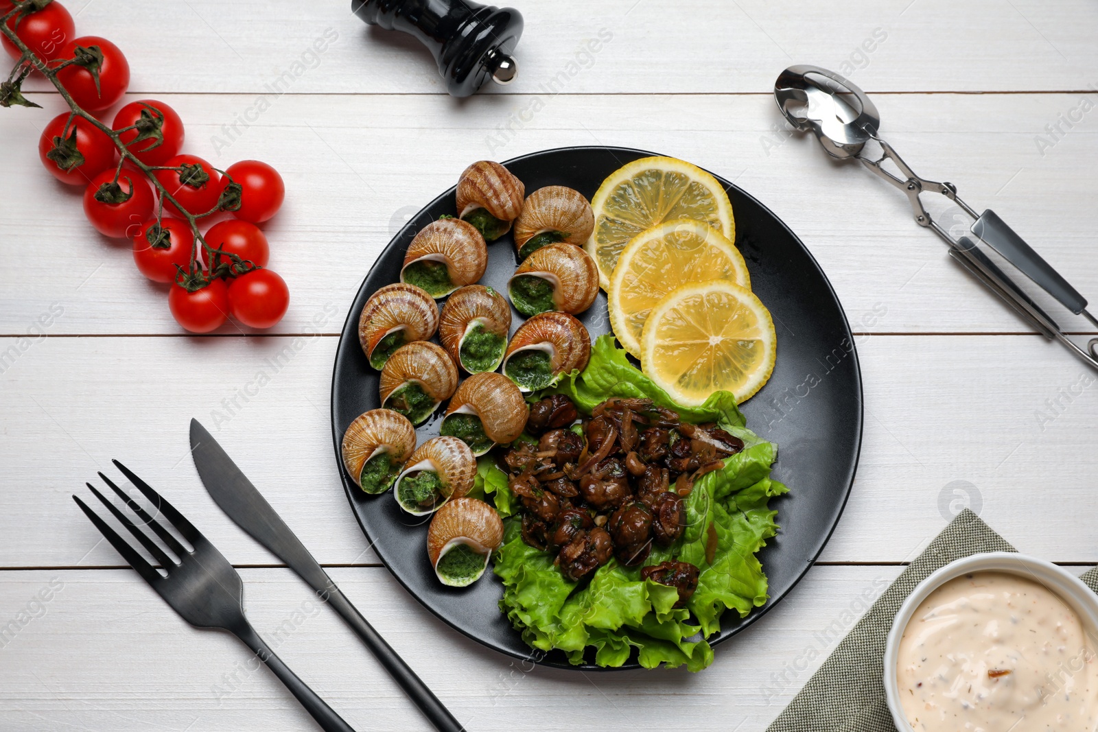 Photo of Delicious cooked snails served on white wooden table, flat lay