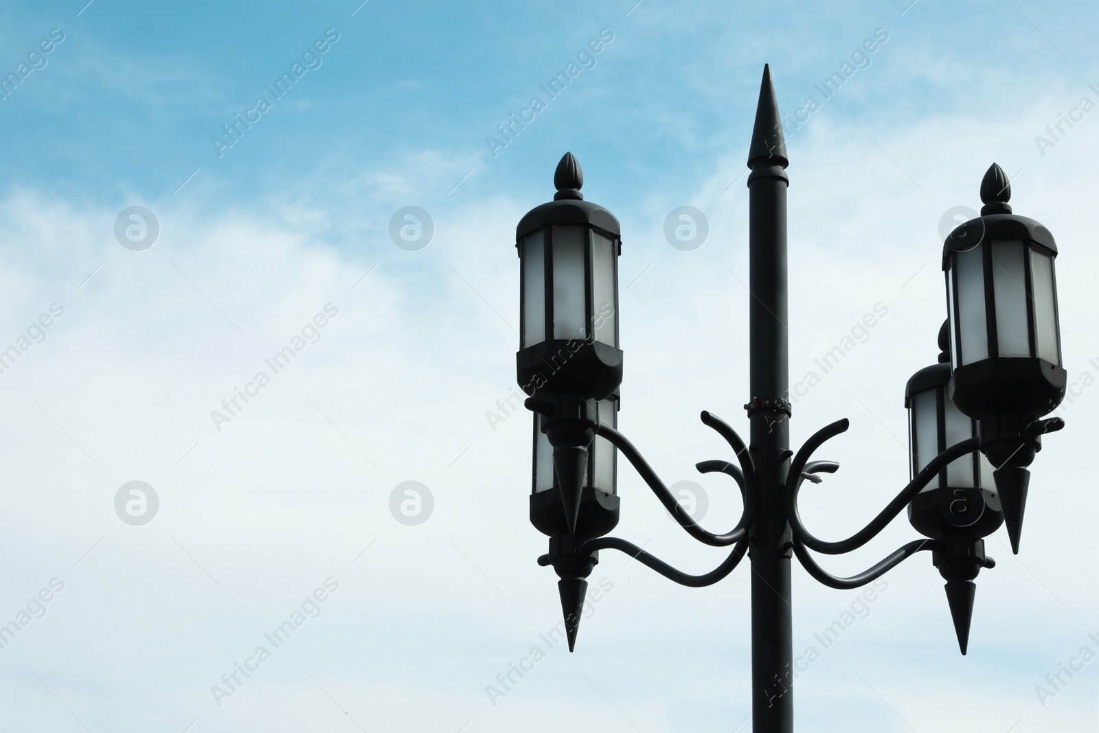 Photo of Old fashioned street light lamp against cloudy sky