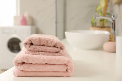 Photo of Stack of clean towels on bathroom countertop. Space for text