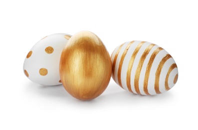 Photo of Set of traditional Easter eggs decorated with golden paint on white background