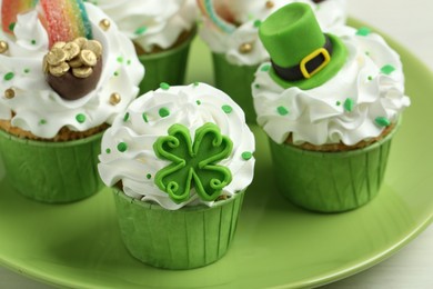 St. Patrick's day party. Tasty festively decorated cupcakes on table, closeup