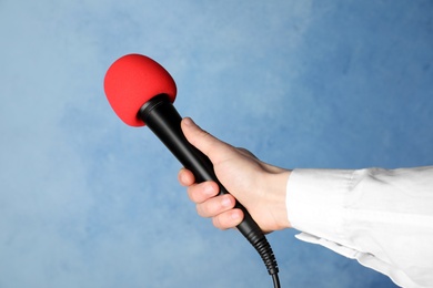 Photo of Woman holding microphone on color background, closeup