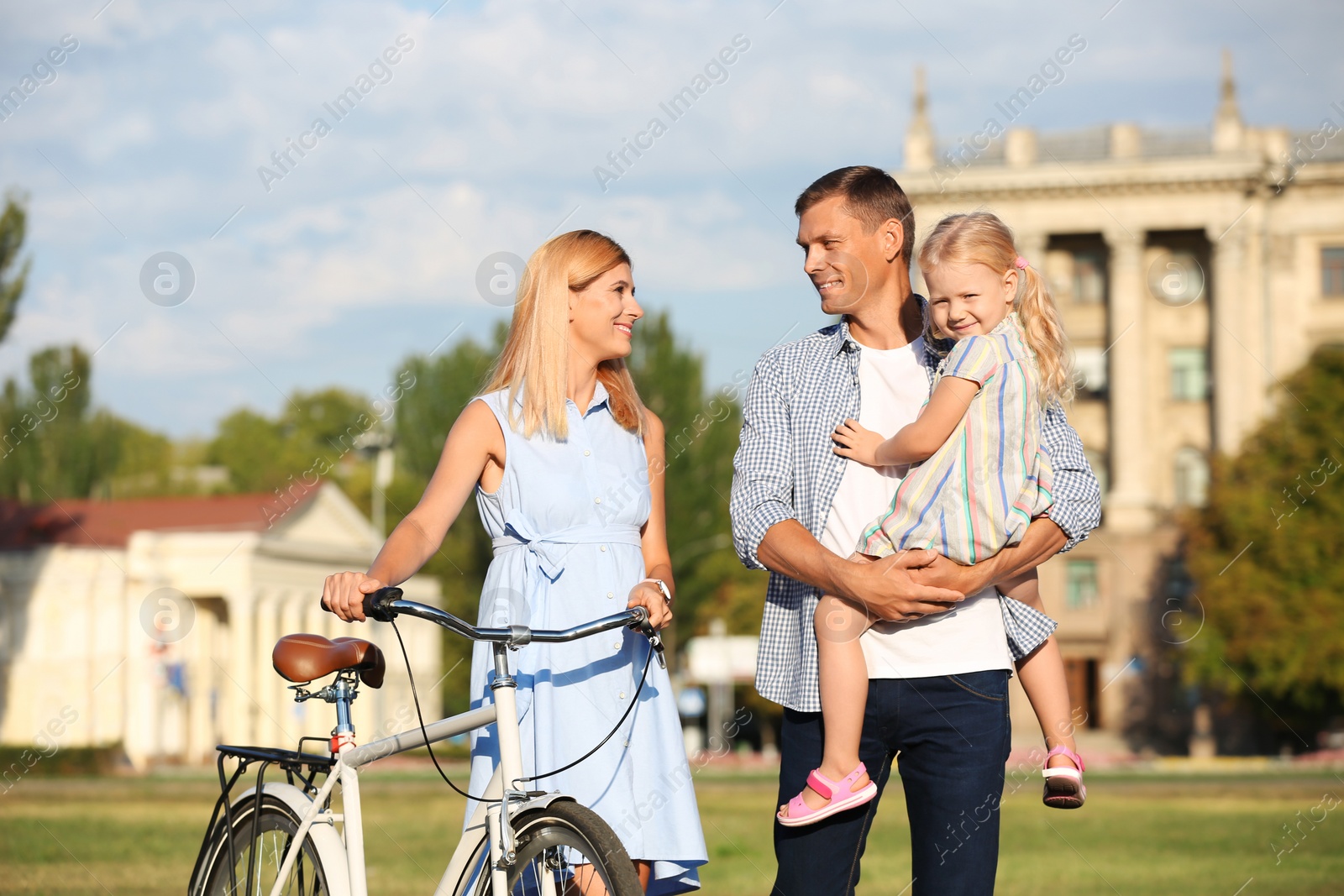 Photo of Happy family with bicycle outdoors on sunny day