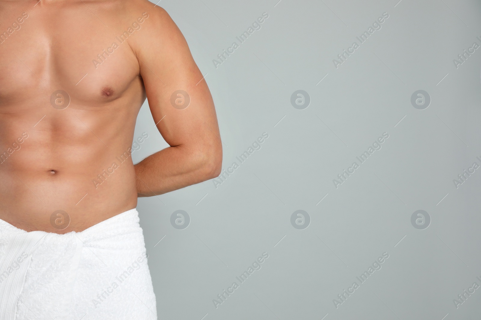 Photo of Young man with slim body on grey background, closeup view. Space for text