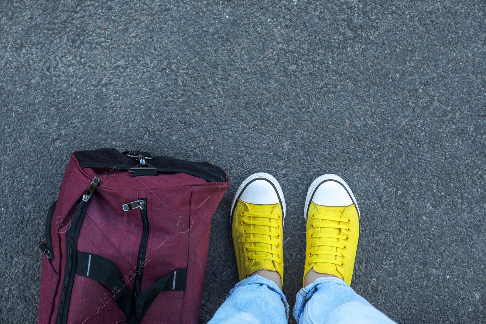 Photo of Woman with bag standing on asphalt, top view. Space for text