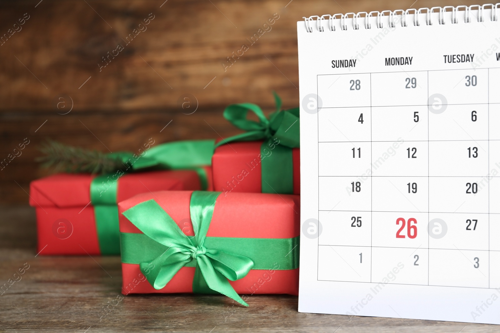 Photo of Calendar with Boxing Day date near gifts on wooden table