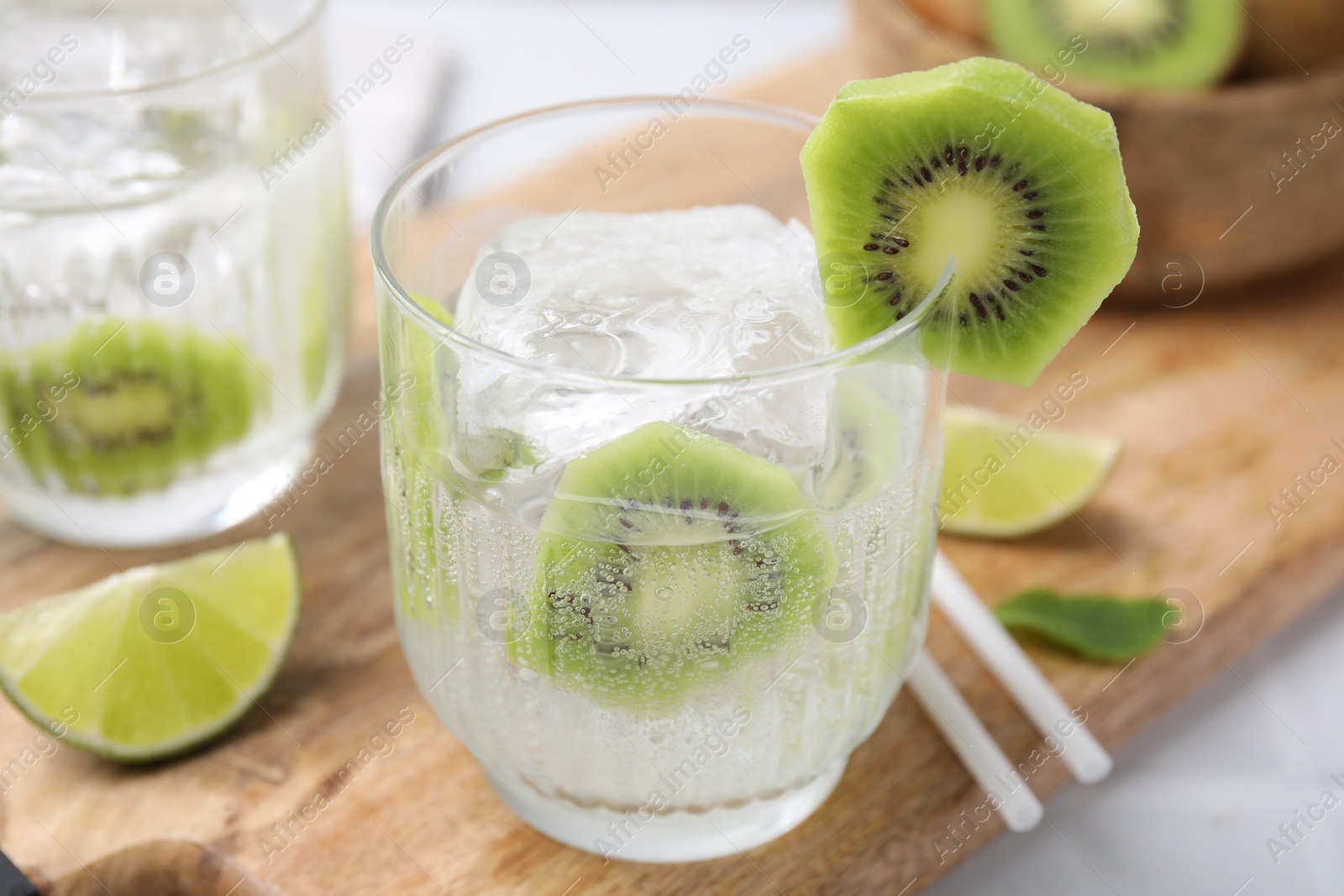 Photo of Refreshing drink, cut kiwi and lime on table, closeup