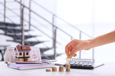 Photo of Woman stacking coins on table. Tax calculation