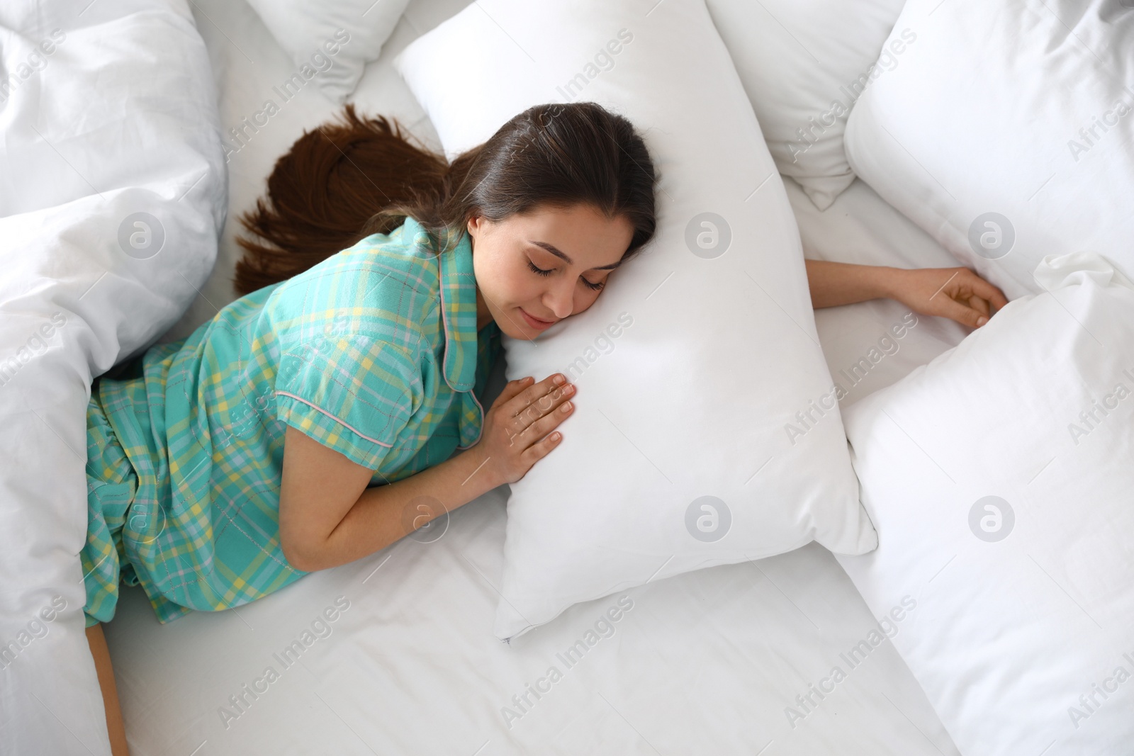 Photo of Portrait of beautiful young woman sleeping in large bed, above view