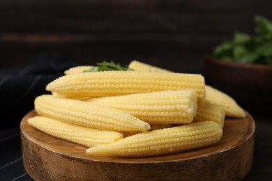 Photo of Tasty fresh yellow baby corns on wooden table, closeup