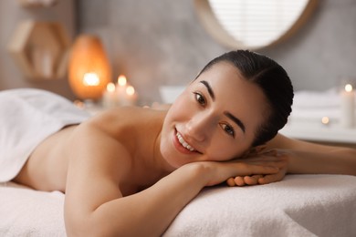 Photo of Beautiful woman relaxing on massage couch in spa salon