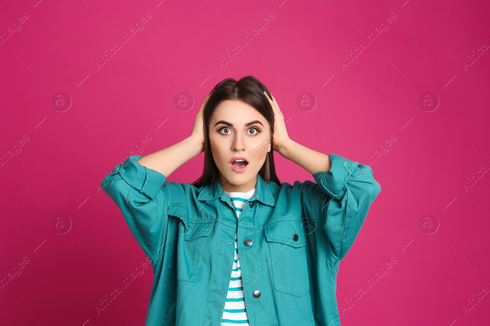 Photo of Portrait of shocked young woman on pink background
