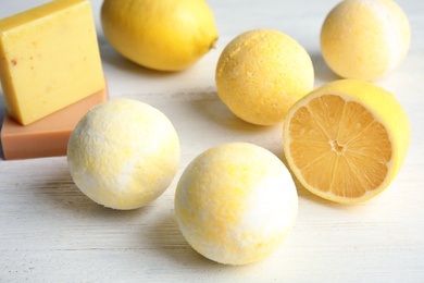 Bath bombs and lemon on white wooden background